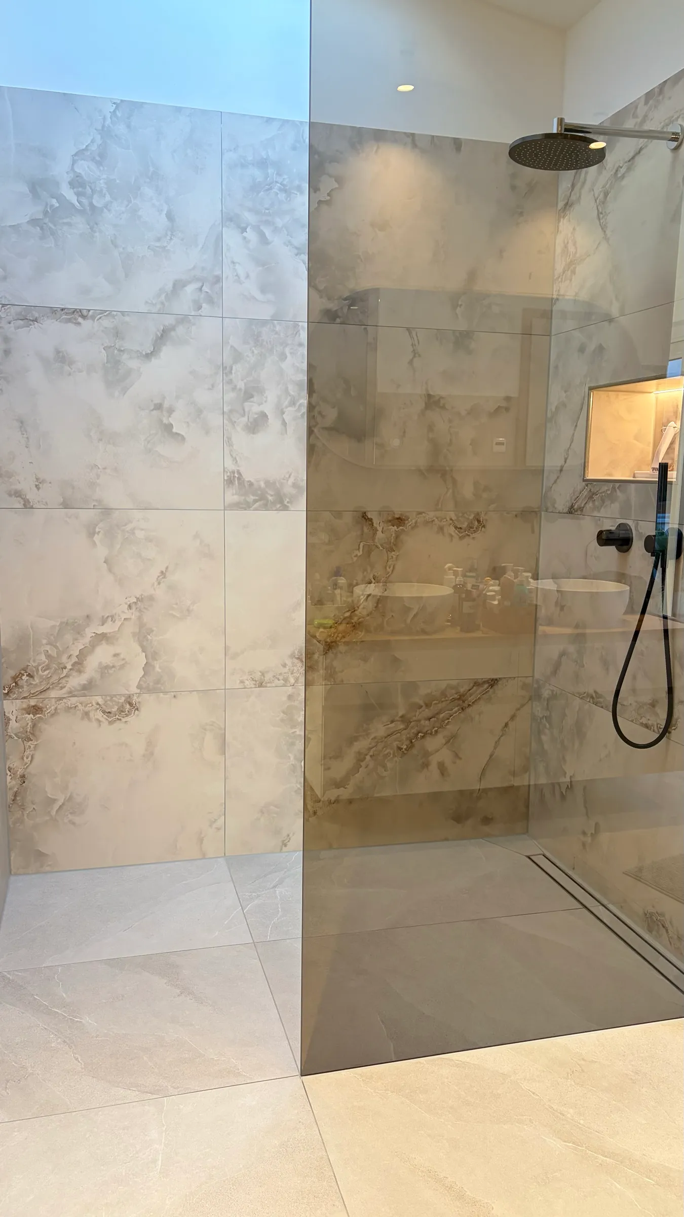 Walk-in-Dusche mit Onyx-Fliesen, Regenbrause und getönter Glaswand
