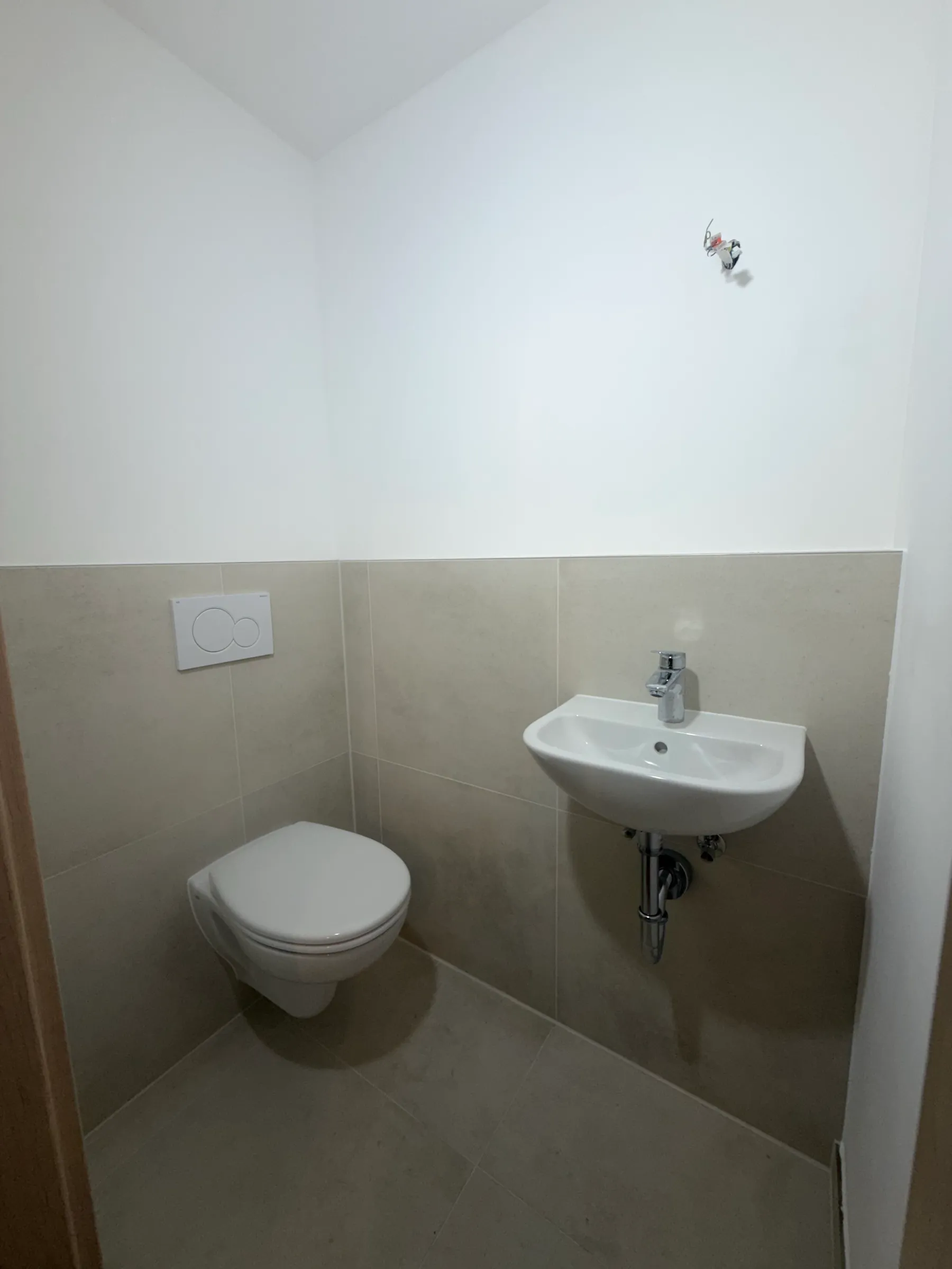 Neues Gäste-WC mit wandhängendem WC und kleinem Waschbecken
