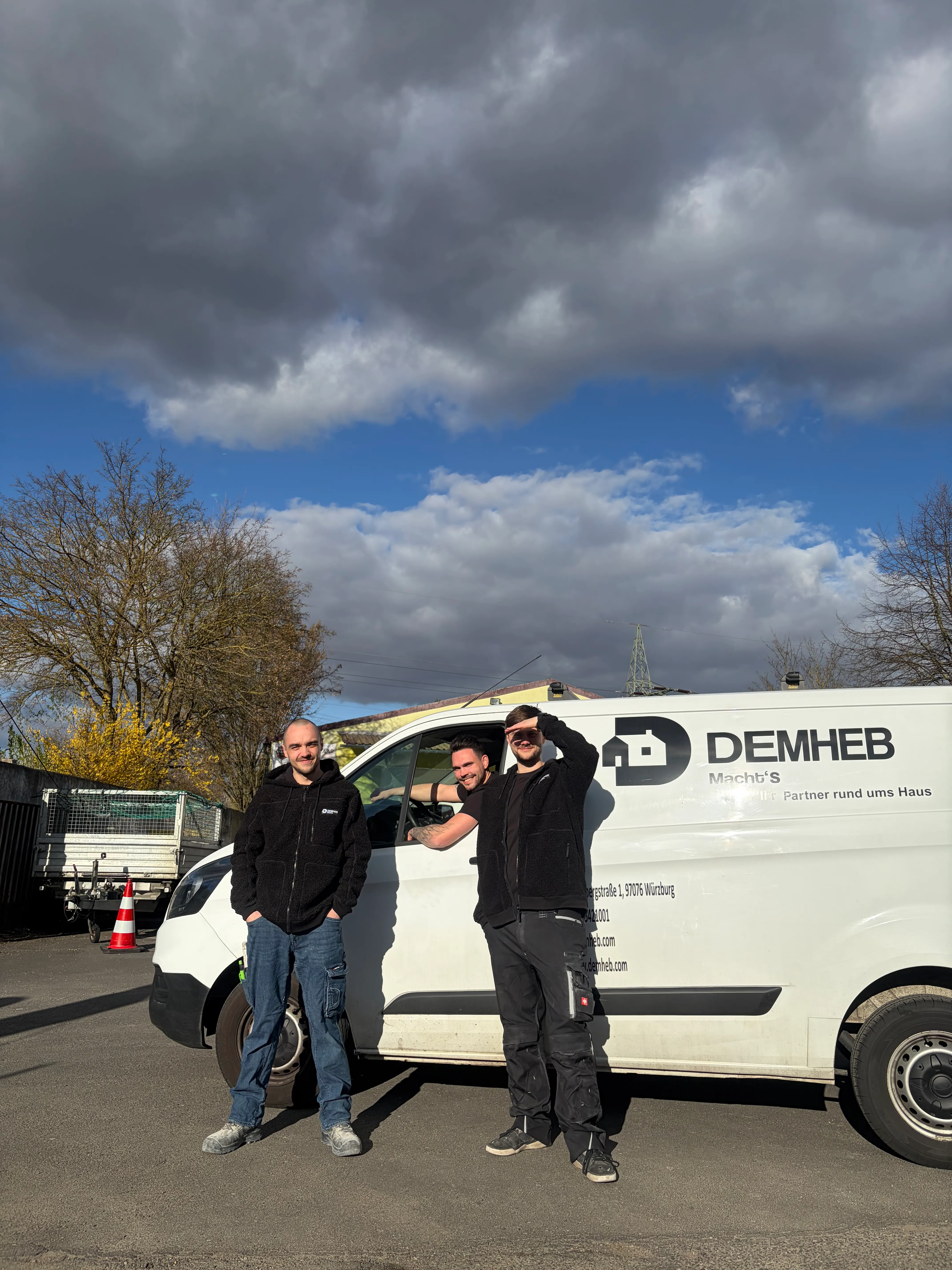 DEMHEB-Handwerker vor dem Firmenwagen